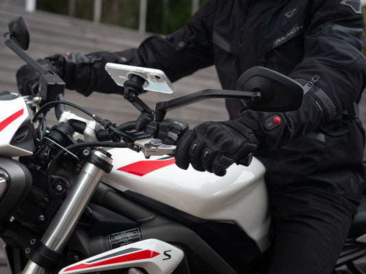 Un motard souriant, prêt à partir avec son équipement complet, reflétant la sérénité d’une conduite bien préparée. Une invitation à adopter les bons réflexes pour rouler en toute confiance.