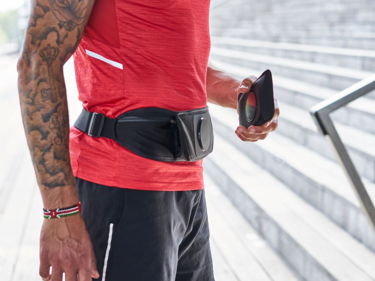 Coureur ajustant une ceinture porte-dossard avant une course officielle.