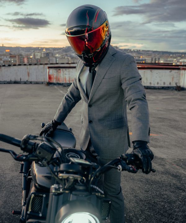 Motard équipé pour la ville avec un casque léger et un sac à dos compact.