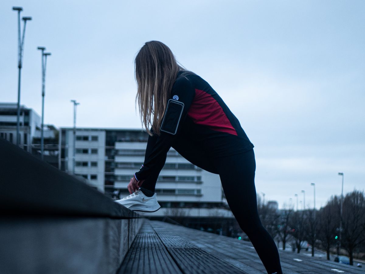 Runner écoutant de la musique avec des écouteurs sans fil pendant un entraînement.