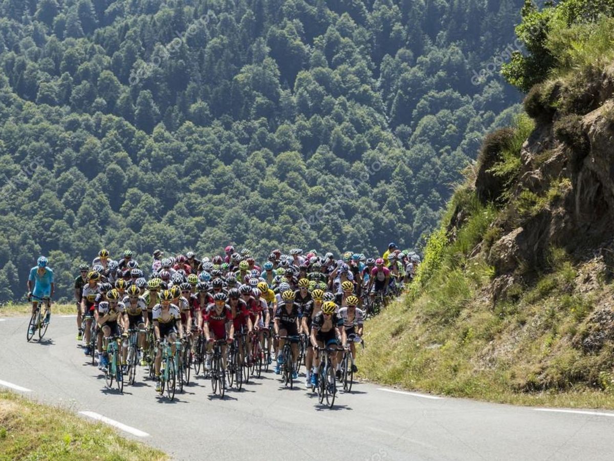 Peloton grimpant un col alpin légendaire sous le soleil.