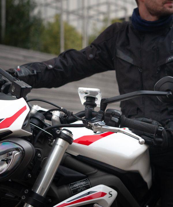 Un motard portant une veste réfléchissante avec son feu allumé, illustrant l'importance d’être visible. L’image insiste sur l’équipement de sécurité pour réduire les risques d’accident.