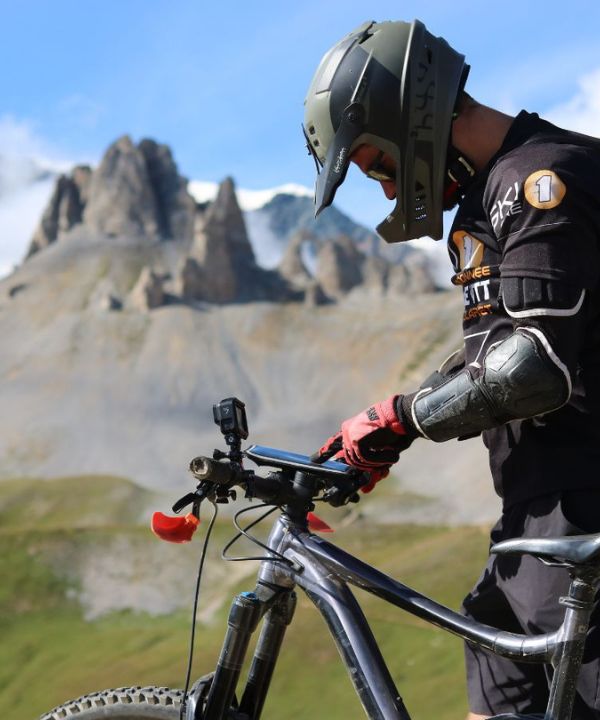 Téléphone fixé sur un guidon Shapeheart avec GPS affiché, soulignant l’utilité d’un smartphone visible en VTT de descente.