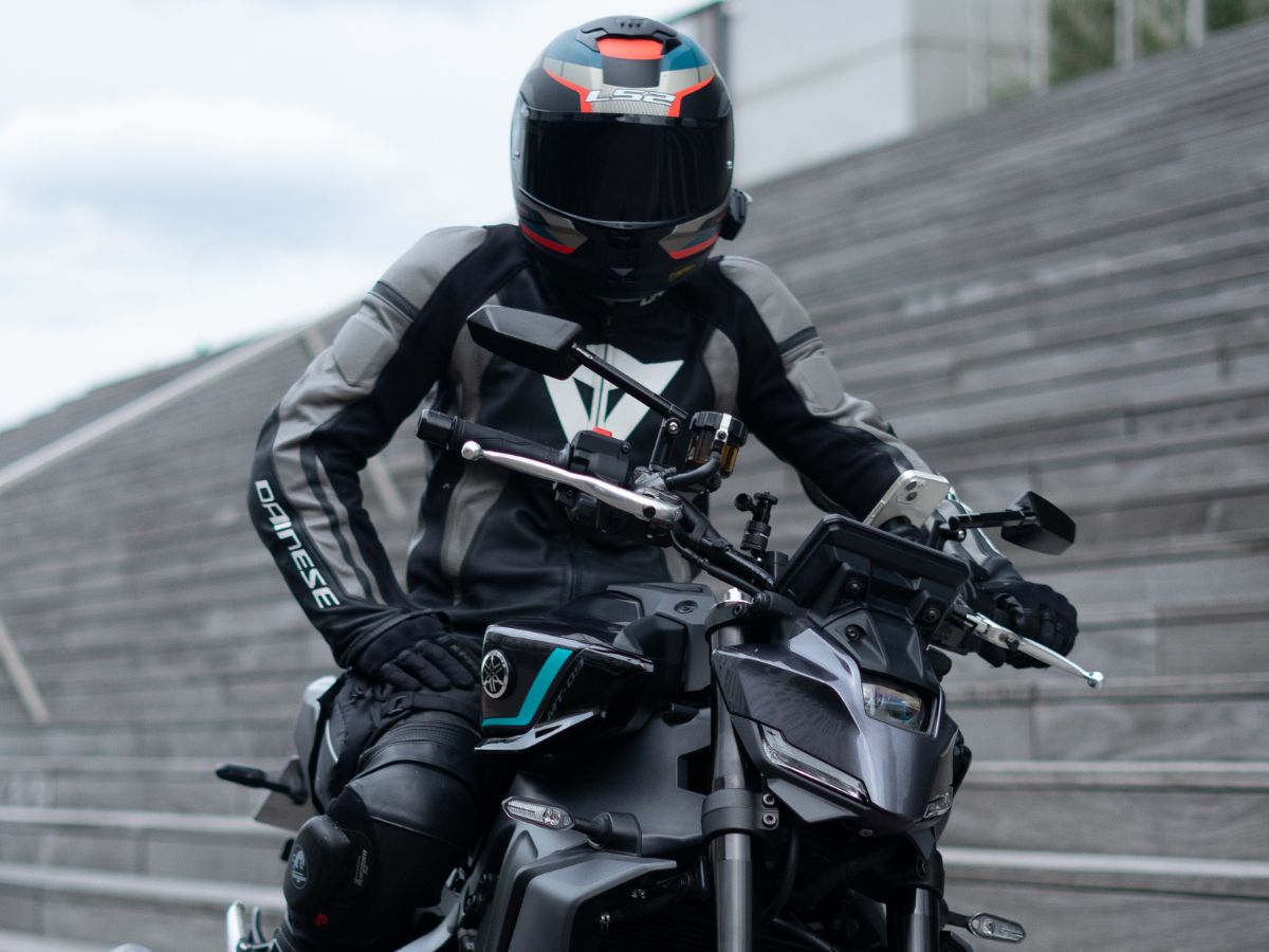 Moto avec deux personnes en virage, montrant l'adaptation de la conduite avec un passager à l’arrière.