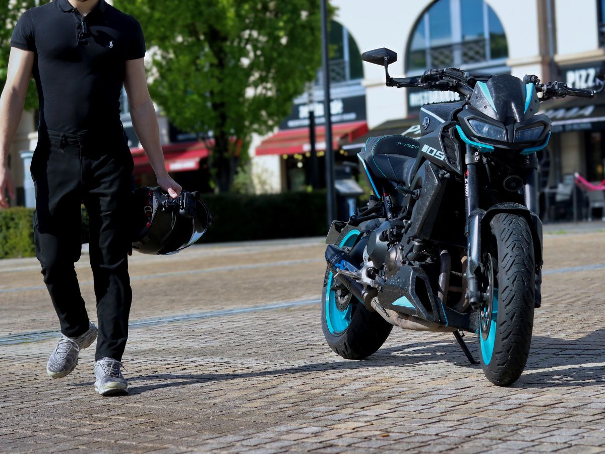 Motard expliquant les consignes de base à son passager avant le départ, pour une meilleure stabilité à moto.