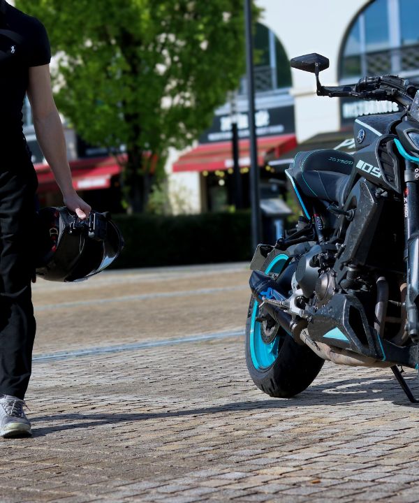 Motard expliquant les consignes de base à son passager avant le départ, pour une meilleure stabilité à moto.