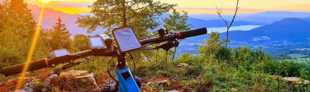 Cycliste consultant un smartphone et un GPS vélo côte à côte avant une sortie, illustrant le choix entre deux options de navigation.